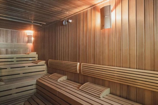 Drewniana sauna z ławkami i oparciami.