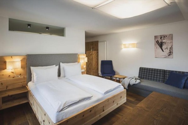 Nowoczesny pokój hotelowy z drewnianymi meblami i podwójnym łóżkiem.