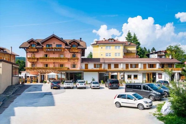 Hotel z parkingiem i spokojnym otoczeniem pod niebieskim niebem.