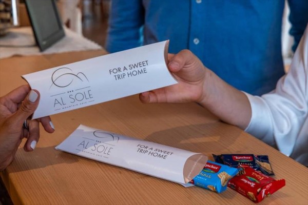 Dwie osoby podają sobie paczkę z napisem 