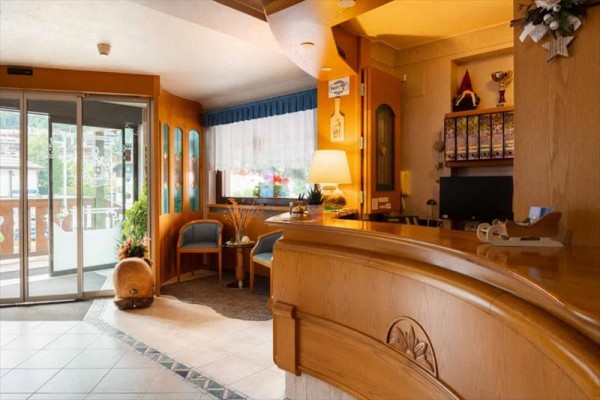 Recepcja hotelowa z drewnianymi meblami i dekoracjami.