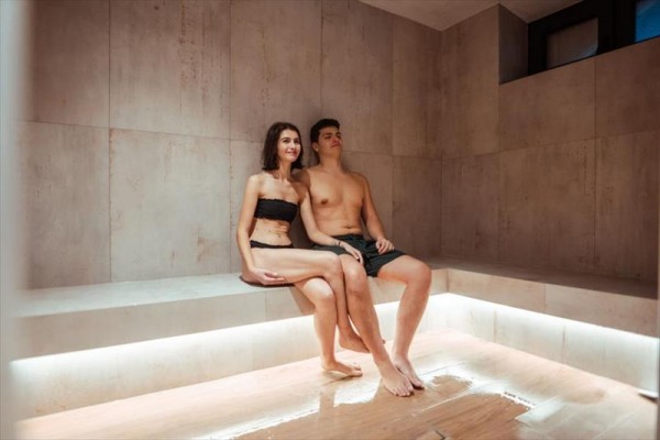 Młoda para siedzi w saunie wellness.