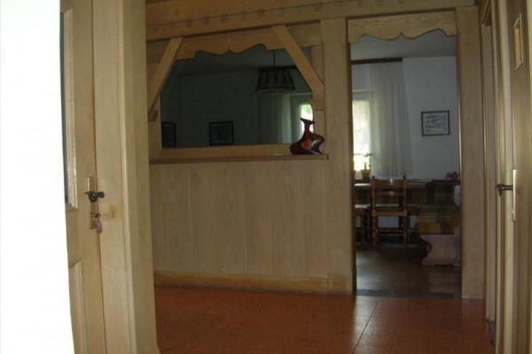 Korytarz z drewnianym prześwitem do sąsiedniego pomieszczenia.