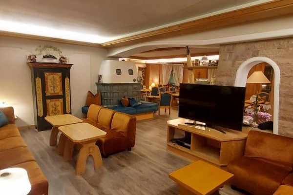 Stylowy salon z drewnianymi meblami, kominkiem i telewizorem.