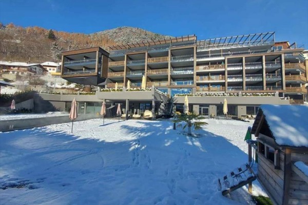 Nowoczesny budynek hotelowy z zaśnieżonym otoczeniem i czystym niebem.