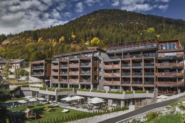 Nowoczesny hotel przy lesie u podnóża góry.