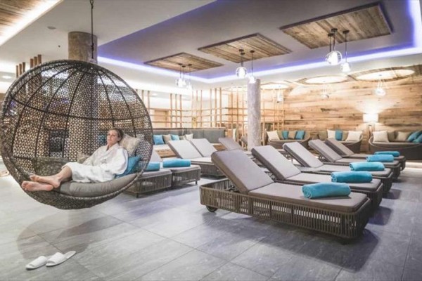 Osoba w szlafroku relaksuje na wiszącym fotelu w nowoczesnym centrum wellness.