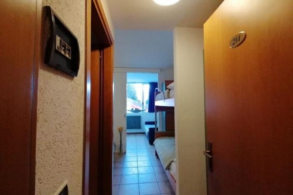 Łazienka z toaletą, kabiną prysznicową i białymi płytkami.
