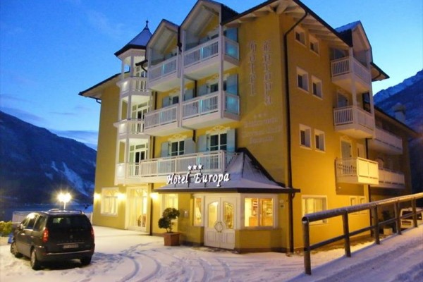 Hotel Europa w zimowej górskiej scenerii o zmierzchu.