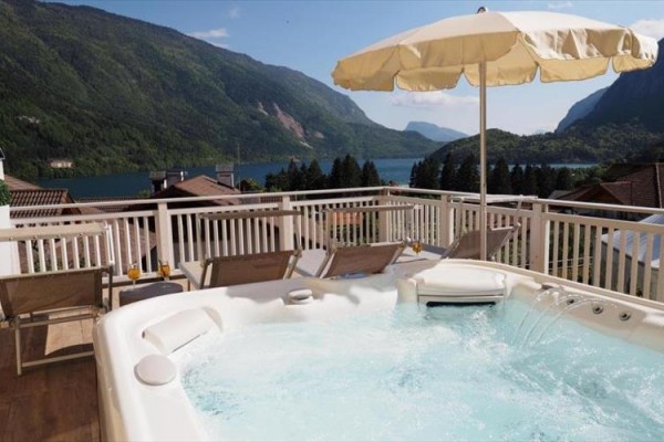 Jacuzzi na tarasie z widokiem na jezioro i góry.