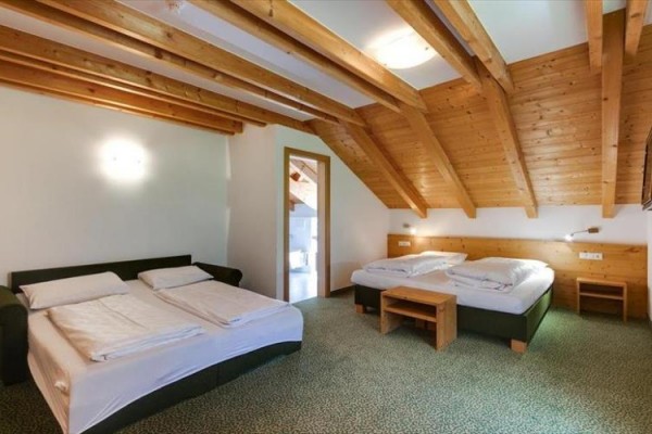 Pokój dwuosobowy z drewnianymi sufitami i dwoma podwójnymi łóżkami.