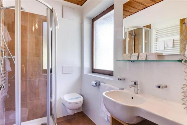 Nowoczesna łazienka z toaletą, kabiną prysznicową i umywalką.