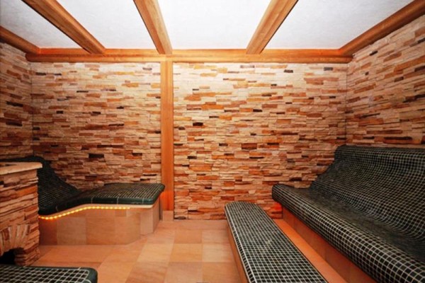 Pomieszczenie z ceramicznymi leżankami i ścianami z naturalnego kamienia.