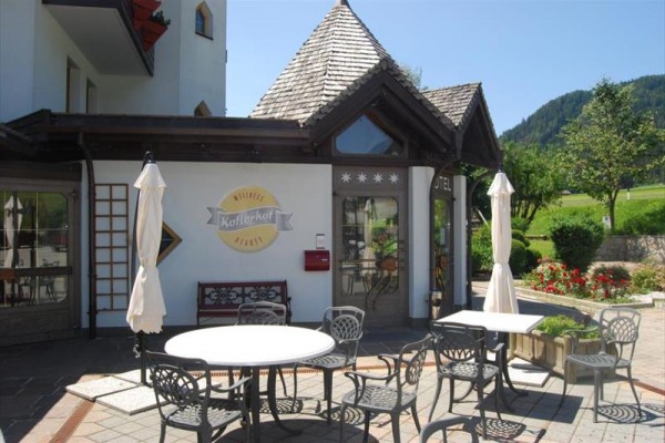 Kawiarnia z miejscami do siedzenia na zewnątrz i górami w tle.