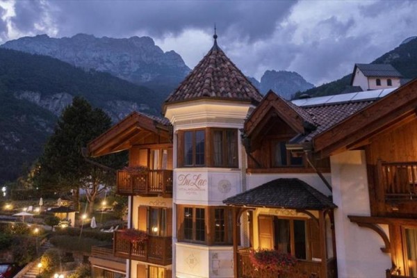 Hotel w wieczornym oświetleniu z górami w tle.
