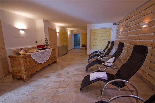 Pokój relaksacyjny z leżakami i drewnianą komodą.