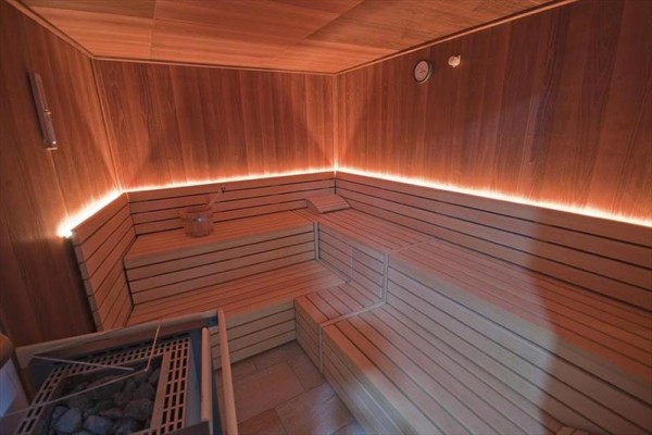 Wnętrze sauny z ławkami z jasnego drewna.