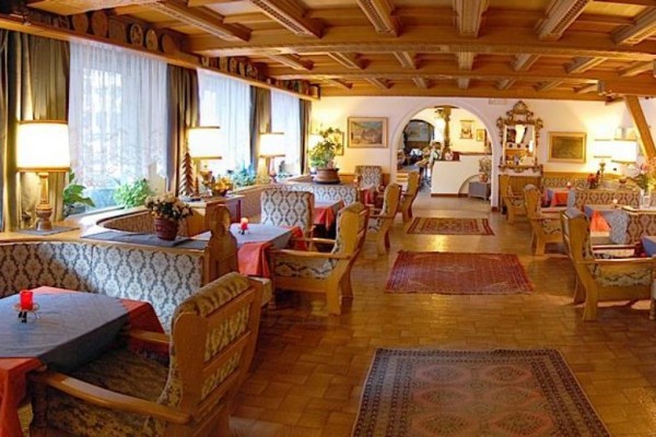 Tradycyjna restauracja z drewnianym wnętrzem i przytulnymi boksami do siedzenia.