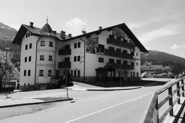 Tradycyjny wielopiętrowy budynek z wieżyczką przy wiejskiej drodze.