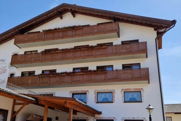 Budynek z drewnianymi balkonami i dekoracyjnymi oknami.