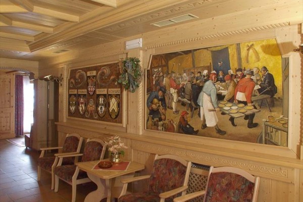 Wnętrze pokoju z ozdobnym drewnianym wykończeniem i malowidłem ściennym.