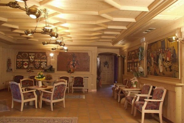 Eleganckie wnętrze z drewna z kilkoma stołami i obrazami na ścianach.