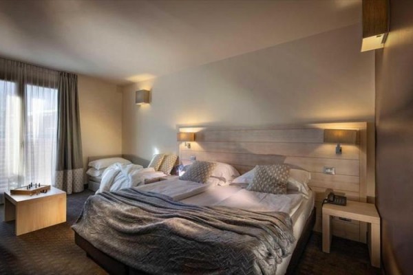 Nowoczesny pokój hotelowy z dużym łóżkiem i szachownicą na stole.