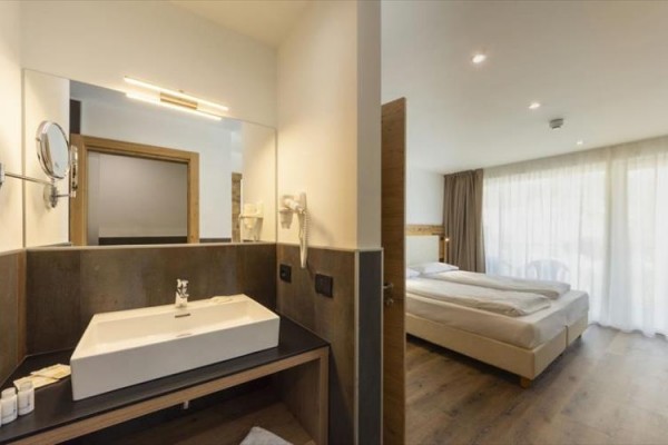 Nowoczesny pokój hotelowy z łóżkiem dwuosobowym i łazienką.
