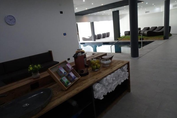 Nowoczesna przestrzeń wellness z basenem i leżakami do wypoczynku.