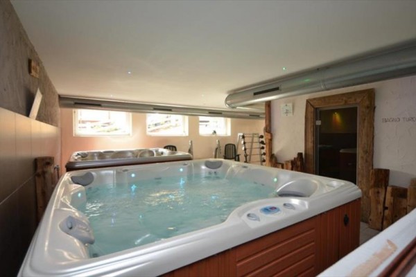Wnętrze z jacuzzi, dużymi oknami i przyległą sauną.