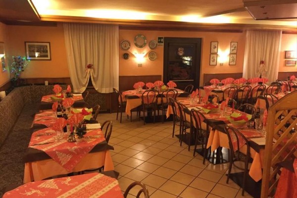 Restauracja z nakrytymi stołami w ciepłych odcieniach pomarańczowego.