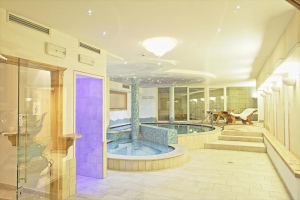 Nowoczesne centrum wellness z dwiema wannami z hydromasażem i leżakami.