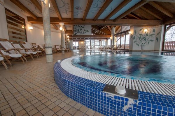 Wnętrze centrum wellness z basenem i leżakami.