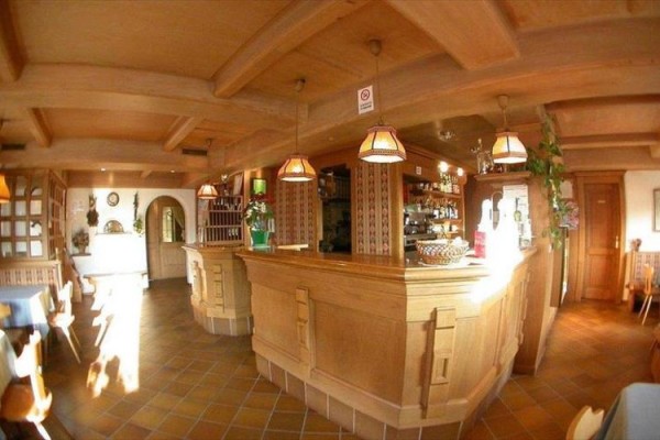 Wnętrze przytulnej restauracji z drewnianymi meblami i barem.  