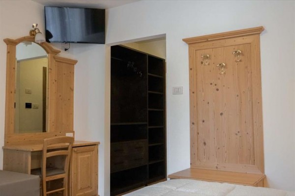 Wejście do górskiego hotelu San Valier z nowoczesnym designem i drewnianymi detalami.