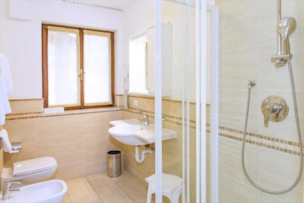 Pokój hotelowy z sofą, łóżkiem i drewnianymi meblami.