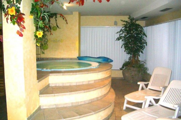 Hotel z drewnianymi balkonami ozdobionymi kwiatami i zewnętrznym tarasem.