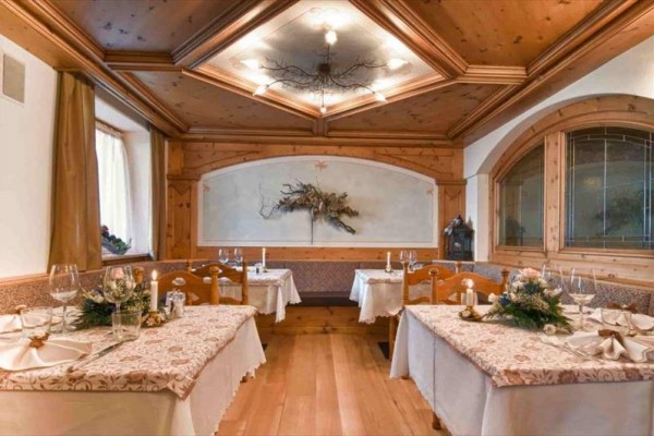 Restauracja z drewnianą boazerią i dekoracyjnymi ozdobami na stołach.