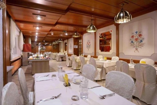 Stylowa restauracja z drewnianą boazerią i stołem gotowym na kolację.  