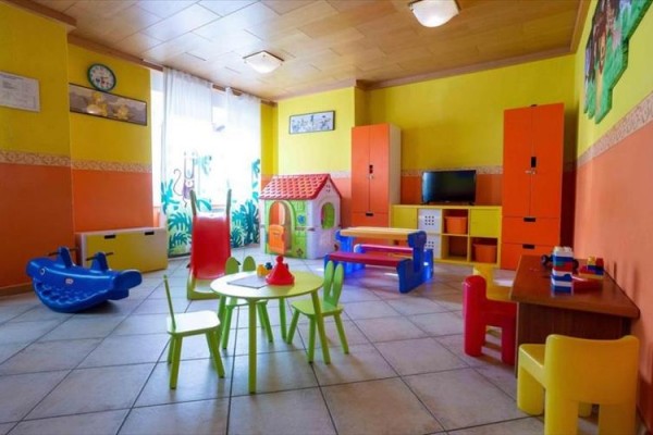 Kolorowa sala zabaw dla dzieci z zabawkami i meblami.