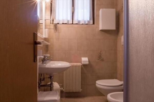 Mała łazienka z umywalką, toaletą i ogrzewaniem.
