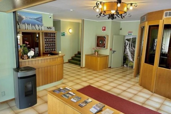 Recepcja hotelowa z drewnianym blatem i dekoracjami.