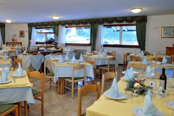 Restauracja z nakrytymi stołami i obrusami w pastelowych kolorach.