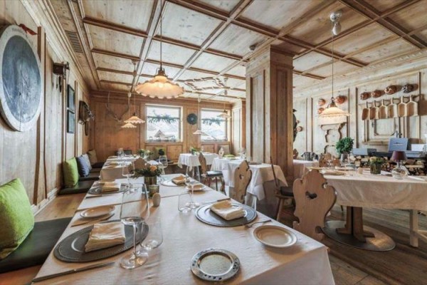 Przytulna restauracja urządzona w drewnianym stylu z nakrytymi stołami.