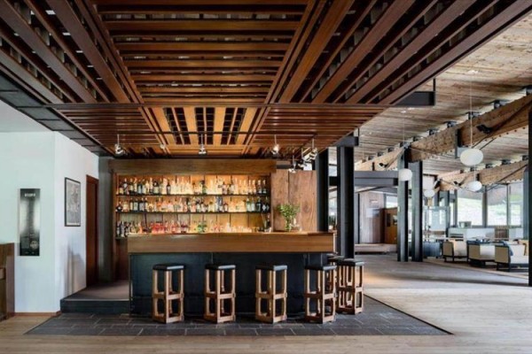 Nowoczesny bar z drewnianymi stołkami w przestronnym wnętrzu.