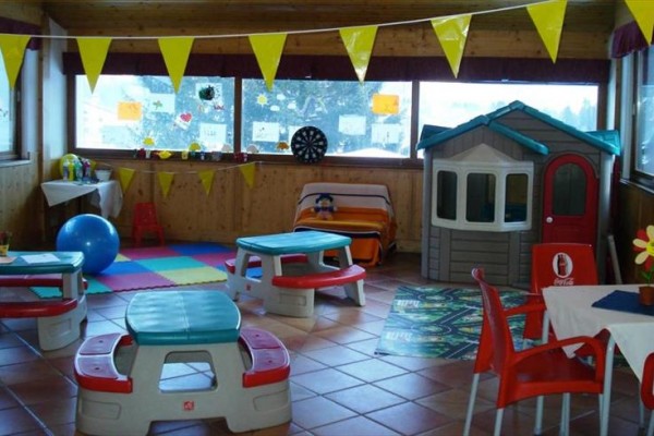 Sala zabaw dla dzieci z kolorowymi meblami i zabawkami.