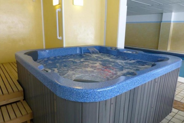 Wnętrze z jacuzzi na drewnianym podium z bąbelkami w wodzie.  