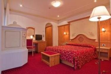 Pokój hotelowy z czerwonym dywanem i drewnianymi meblami.