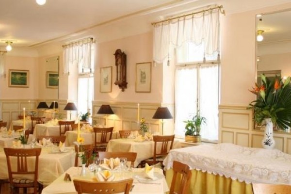 Elegancko urządzona restauracja z nakrytymi stołami i ozdobnymi kwiatami.