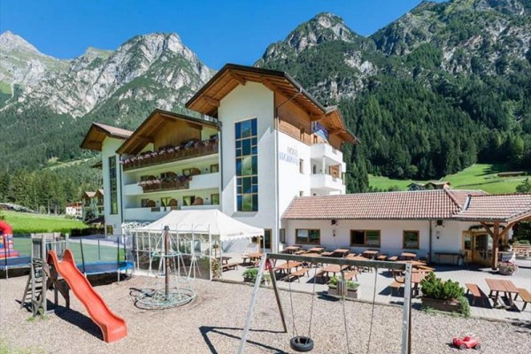 Nowoczesny hotel z placem zabaw na tle gór.